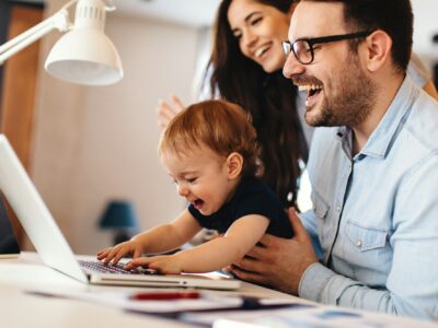 Young parents and their toddler son have a video call via laptop at home